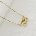 Collier en acier inoxydable doré avec pendentif '2005' sur fond blanc doux - 2015