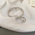Detail of silver snake-shaped open bangle and matching ring on elegant silk fabric - Snake Shape Set / Silver