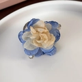 Dettaglio di un fermaglio per capelli camelia in rete blu e beige su un piatto - Beige Blu