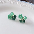 Detailed view of green opal floral earrings with crystals on a vintage ceramic plate - Green