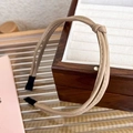 Detail of beige knotted leather headband showing the woven texture and soft PU material - Off White