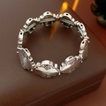 Close-up of vintage silver bracelet featuring ornate floral engravings and beaded edges - Silver