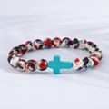 Detail of colorful beads with turquoise cross on minimalist white fabric background - Multi-color Red Black White Turquoise Cross