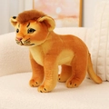 Realistic lion plush toy with soft brown mane standing on a modern cream sofa - Lion / 26cm