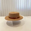 Klassischer Strohhut mit braunem Lederband auf einem modernen, strukturierten Ständer - M (56-58cm) / Khaki