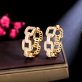 Close-up of golden chain link hoop earrings with pavé set white zircon stones - Gold