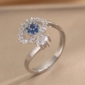 Silver evil eye heart ring with blue and white zircons on a beige background - Evil Eye (646) / Silver