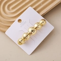 Elegant gold barrette with five textured spheres on white card against beige background - Hammered Ball Chain Gold