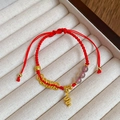 Macro shot of red woven bracelet with golden zodiac snake charm and lucky coins - Zodiac Snake with Gray Agate Style (5684120033493)