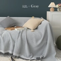 Gray waffle knit sofa throw blanket with decorative tassels displayed on a couch - Gray