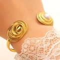 Vintage gold twisted open bangle featuring a large pearl detail on a woman's wrist - Vintage Wire Wrap Pearl (1350)