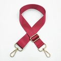 Close-up of adjustable wine red nylon bag strap with polished gold metal hardware - Burgundy