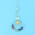 Detail of a golden crescent moon suncatcher with vibrant colorful raw crystal stones - Rainbow