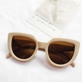 Fashionable cat-eye sunglasses featuring cream frames and brown lenses on a fabric texture - Off White