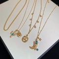 Detailed close-up of gold western cowboy hat, boot, and cactus pendants on layered chains - Gold