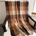 Detail of coffee plaid tassel scarf draped on a white chair in a cozy indoor setting - Brown & Coffee Plaid