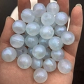 Macro shot of luminous blue DIY beads with iridescent glitter on a person's palm - 16mm / Blue