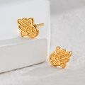 Elegant gold Hamsa Hand stud earrings in stainless steel on white stone background - Hamsa Hand / Gold