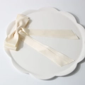 Elegant cream white satin bow hair clip with long ribbons on a ceramic petal plate - Cream