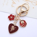Portachiavi dorato con cuore rosa rossa e ciondoli a fiore su carta decorativa - Fiore Piccolo di Rosa