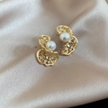 Detalle de pendientes de mariposa con perlas y circonitas sobre satén color champán - Dorado