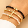 Set di tre bracciali elastici con perline e ciondoli a croce dorata in nero, oro e perla - Set da 3 Pezzi Croce (10916)
