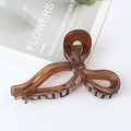 Elegant large brown translucent bow hair claw clip for thick hair shown on a magazine - Brown