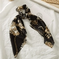 Detail of a black satin scrunchie with a gold chain pattern and long streamers - Black Chain
