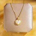 Élégant collier cœur en perle dorée avec bord torsadé sur fond de soie champagne - Collier Coeur En Dentelle Dorée