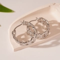 Detailed view of silver braided chain link hoop earrings on a decorative stone base - Silver Chain Ear Buckle