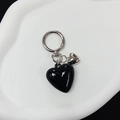 Detail shot of a black resin heart pendant with a small silver heart and metal buckle - Black
