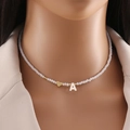 Detail of beaded necklace featuring a gold heart and a white shell letter A pendant - Letter A