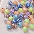 Gros plan de perles de sport en acrylique colorées sur soie rose pour bijoux artisanaux - Style Football (10mm-Couleur mixte avec lignes argentées) / 50 Pcs/Paquet