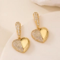 Eleganti orecchini a cuore placcati oro 18 carati con zirconi lucidi su sfondo beige morbido - Cuore d'Oro Semi-Pavé (45551)