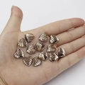 Macro detail of heart-shaped scales charms in champagne gold held in palm for size reference - 12mm Bronze