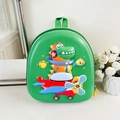 Makroaufnahme eines grünen Kinderrucksacks mit 3D-Dinosaurier-Pilot auf einem Flugzeug - Grün