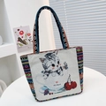 Beige canvas tote bag featuring cute cat cherry embroidery and colorful ethnic style handles - Cat
