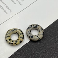 Detail of two 20mm spotted natural stone abacus beads on a black and white background - Dalmatian Jasper