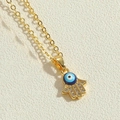 Makroaufnahme von Hamsa-Hand-Anhänger mit blauem Auge und Pavé-Fassung aus Zirkonias - Blaues Öl-Fatima-Hand