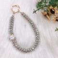Colorful rhinestone beaded phone charm with gold metal clasp on white fur background - Pearl Rhinestone Flower Bead