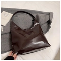 Bolso hobo de cuero sintético brillante granate sobre un abrigo gris de otoño - Marrón