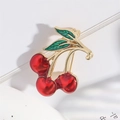 Broche cerise vintage en émail rouge avec cadre doré sur fond blanc pur et net - Rouge