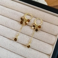 Detalle de pendientes vintage dorados con cuentas de ojo de tigre y borlas en un estuche - Pendiente Estilo Borla Oro Café (HE30218)