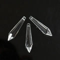 Close-up of three faceted crystal prism pendants for DIY decor on a black background - Pointed Cone Transparent (55mm)