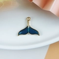 Dettaglio macro di un ciondolo a coda di pesce dorato con smalto blu scuro lucido - Coda di Pesce a Doppia Faccia in Smalto Blu Oro