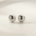 Makroaufnahme von polierten silbernen Kugelohrsteckern mit glänzendem Spiegelfinish - Kugelform (Silber)