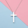 Silver stainless steel cross necklace on a soft pink and blue split background - Steel