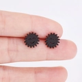 Minimalistische schwarze Sonnenblumen Smiley-Ohrstecker am Finger präsentiert - Schwarz