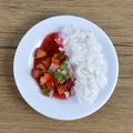 Miniature PVC Chinese rice bowl model with red sauce meat and peppers on white plate - Braised Pork Rice Bowl
