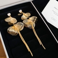 Close-up of golden ginkgo leaf tassel earrings with sparkling zircon on a black velvet box - Real Gold Plated Gold